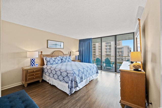 bedroom featuring dark hardwood / wood-style floors, a wall of windows, a textured ceiling, and access to outside