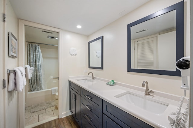 bathroom with hardwood / wood-style floors, vanity, and shower / bath combination with curtain