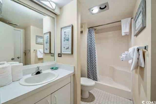 bathroom featuring vanity, curtained shower, and toilet