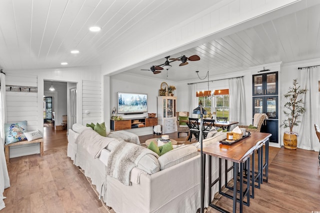 living room featuring crown molding, light hardwood / wood-style floors, lofted ceiling, wooden ceiling, and ceiling fan with notable chandelier