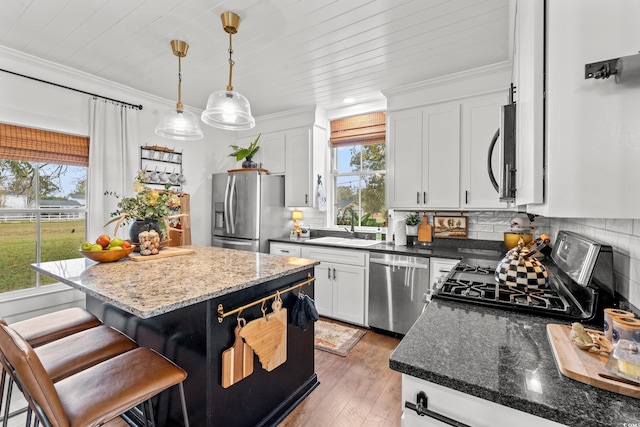 kitchen featuring white cabinets, dark hardwood / wood-style floors, a kitchen island, and appliances with stainless steel finishes