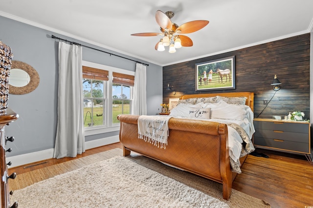 bedroom featuring hardwood / wood-style flooring, ceiling fan, and crown molding