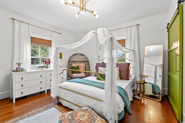 bedroom with hardwood / wood-style floors, a barn door, a chandelier, and ornamental molding