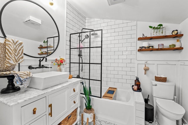 full bathroom with vanity, tiled shower / bath, and toilet