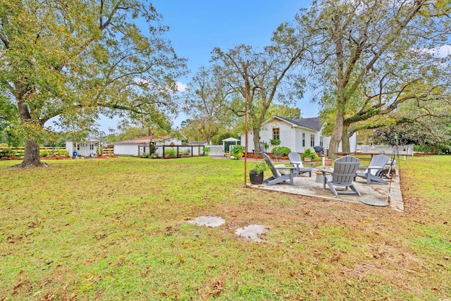 view of yard featuring a storage shed, a patio, and a fire pit