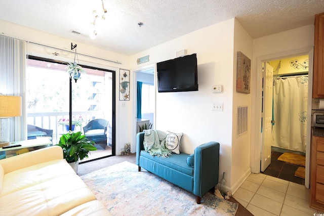 living room featuring light tile patterned flooring and a textured ceiling