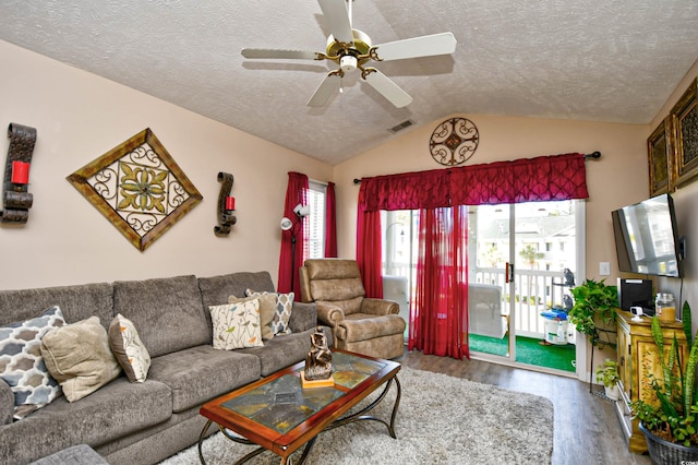 living room featuring a textured ceiling, ceiling fan, wood-type flooring, and lofted ceiling