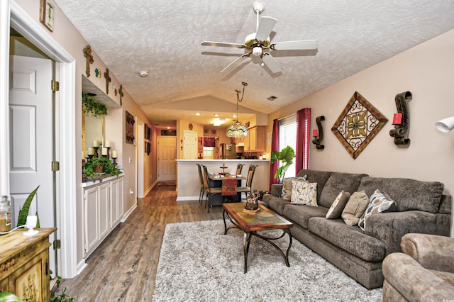 living room featuring a textured ceiling, ceiling fan, vaulted ceiling, and hardwood / wood-style flooring