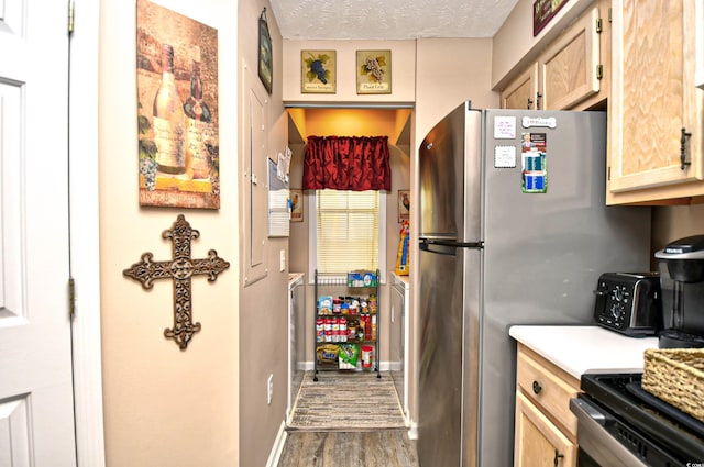 kitchen featuring stainless steel refrigerator, light brown cabinets, dark wood-type flooring, and a textured ceiling