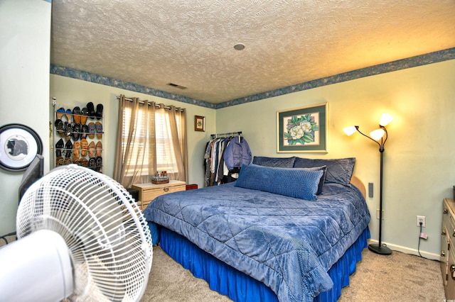 bedroom with light colored carpet and a textured ceiling