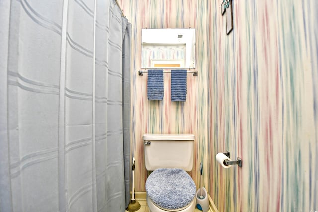 bathroom with toilet and curtained shower