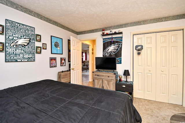 bedroom with carpet flooring, a textured ceiling, and a closet