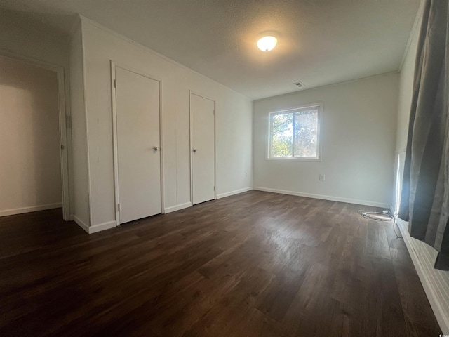 unfurnished bedroom featuring dark hardwood / wood-style flooring