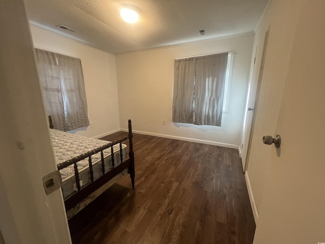 bedroom featuring a textured ceiling and dark wood-type flooring