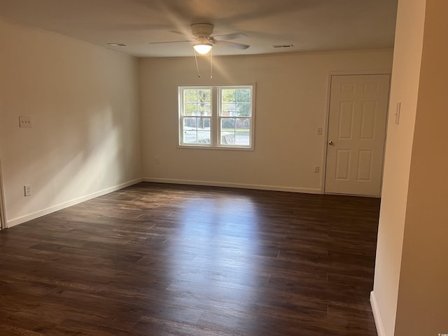 unfurnished room featuring ceiling fan, dark wood-type flooring, and ornamental molding