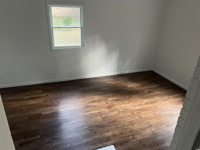 empty room with dark hardwood / wood-style flooring