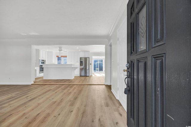 foyer entrance featuring ornamental molding and light wood-type flooring