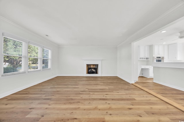 unfurnished living room with light wood-type flooring, ceiling fan, and crown molding