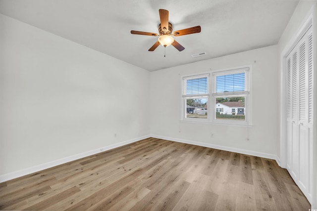 unfurnished bedroom featuring light wood-type flooring, ceiling fan, and a closet