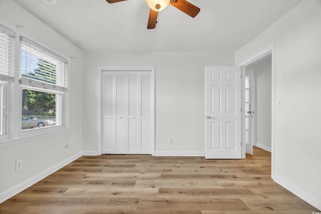 unfurnished bedroom with a closet, light wood-type flooring, and ceiling fan