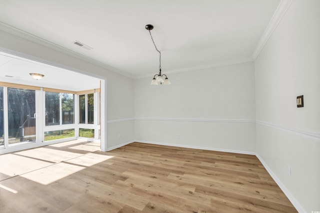 unfurnished room with ornamental molding, a notable chandelier, and light hardwood / wood-style floors