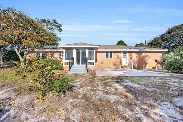 rear view of property featuring a sunroom