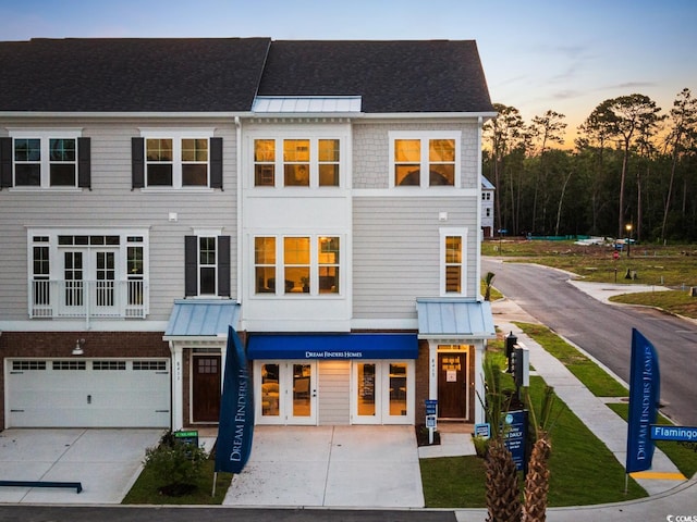 8479 Duke Pl Unit 34, Myrtle Beach, SC 29572 - view of property with concrete driveway, a garage, a standing seam roof, a metal roof, and french doors