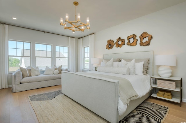 bedroom featuring a chandelier and light hardwood / wood-style floors