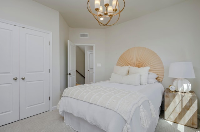 bedroom featuring a notable chandelier, light carpet, and a closet