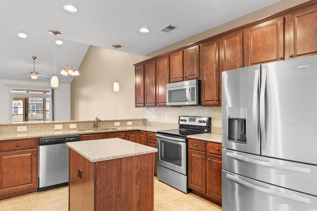 kitchen with sink, kitchen peninsula, pendant lighting, lofted ceiling, and appliances with stainless steel finishes