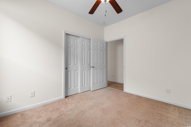 unfurnished bedroom featuring a closet, ceiling fan, and light colored carpet