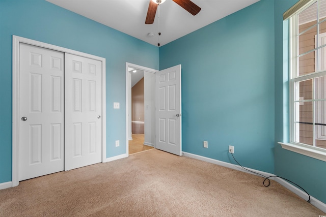 unfurnished bedroom featuring a closet, ceiling fan, and light carpet