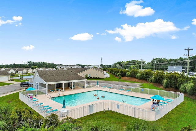 view of pool with a patio area and a lawn