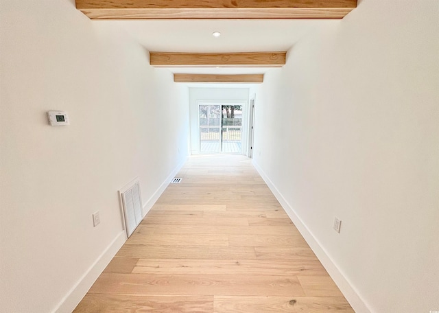 corridor featuring beamed ceiling and light hardwood / wood-style floors