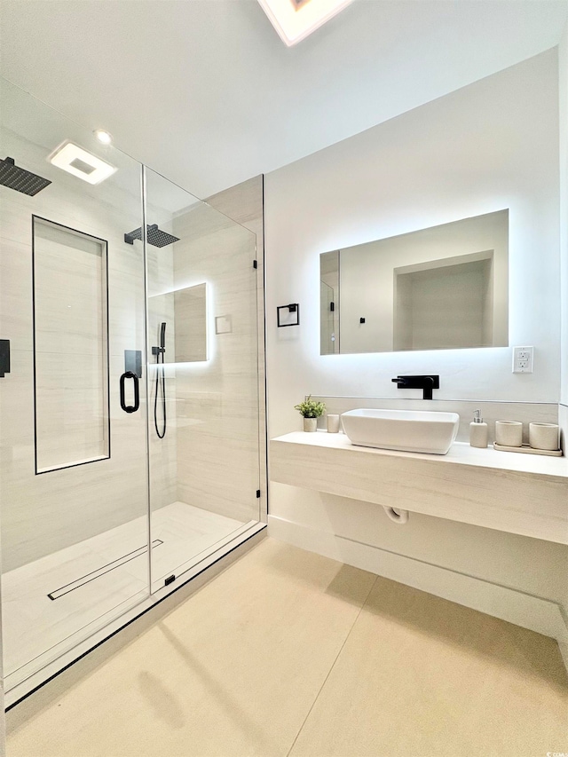 bathroom featuring a shower with door and vanity