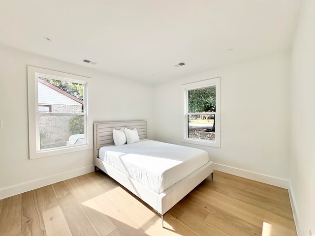 bedroom featuring light hardwood / wood-style flooring and multiple windows