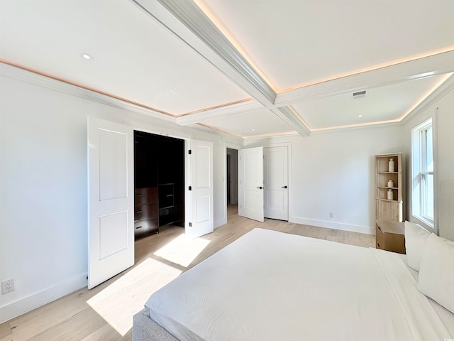 bedroom featuring beam ceiling, ornamental molding, light wood-type flooring, and coffered ceiling