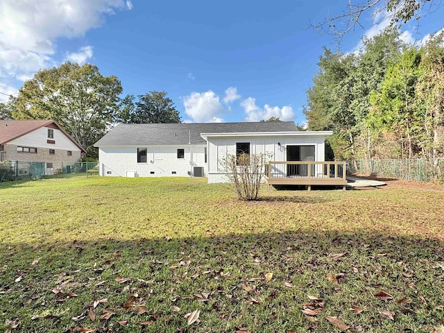 rear view of property featuring central air condition unit, a lawn, and a deck