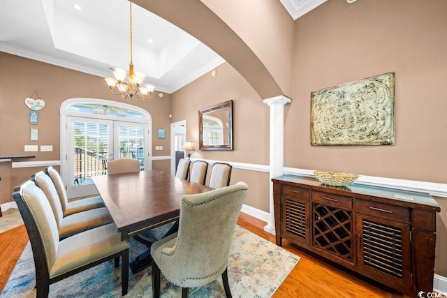 304 76th Ave N Unit D, Myrtle Beach, SC 29572 - dining area featuring a chandelier, arched walkways, ornate columns, light wood-style floors, and a raised ceiling
