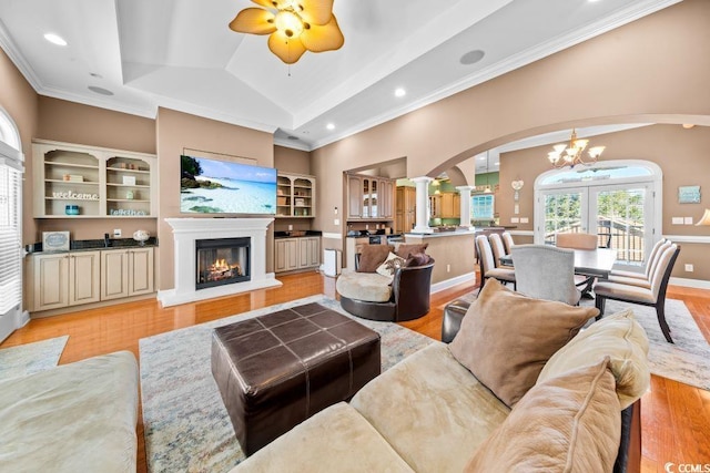 304 76th Ave N Unit D, Myrtle Beach, SC 29572 - living room featuring decorative columns, arched walkways, a chandelier, ornamental molding, and a glass covered fireplace