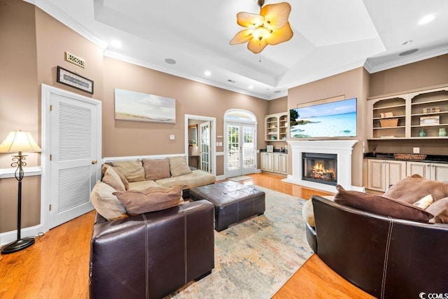 304 76th Ave N Unit D, Myrtle Beach, SC 29572 - living area featuring crown molding, light wood finished floors, recessed lighting, a warm lit fireplace, and a tray ceiling