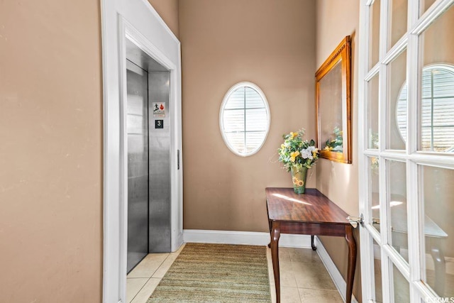 doorway to outside with light tile patterned floors, elevator, and french doors