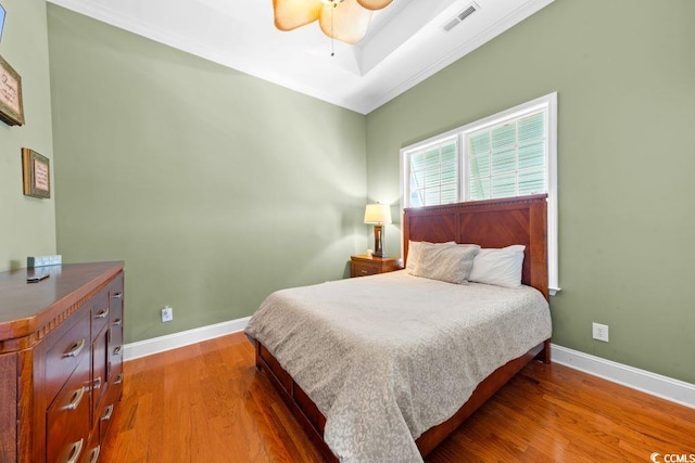 bedroom with hardwood / wood-style flooring, ceiling fan, and ornamental molding