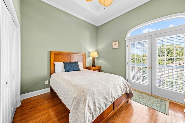 bedroom with access to outside, crown molding, dark hardwood / wood-style floors, ceiling fan, and a closet