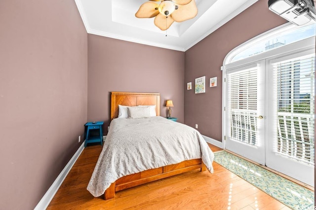 bedroom with access to exterior, hardwood / wood-style flooring, ceiling fan, and crown molding