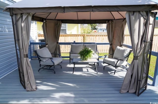 wooden terrace featuring an outdoor hangout area and a gazebo