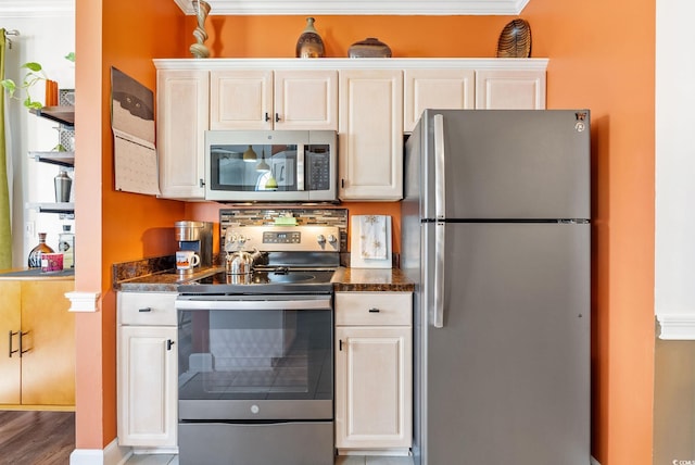 kitchen featuring ornamental molding, stainless steel appliances, and white cabinets