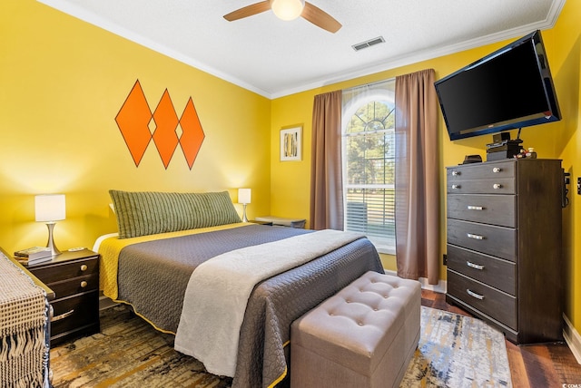 bedroom with dark wood-type flooring, ceiling fan, and ornamental molding