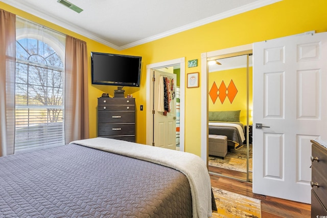 bedroom featuring a closet, hardwood / wood-style floors, and ornamental molding