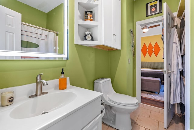 bathroom with toilet, vanity, and tile patterned flooring